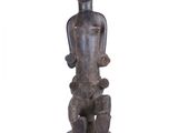 statue of a man holding a baby in his arms on a wooden base