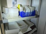 une étagère sur laquelle sont posés de la vaisselle et des récipients, dans une cuisine