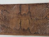 an image of a brown snake skin purse on a white surface