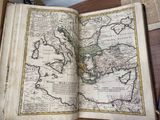an old book with a map of asia on it sitting on a table