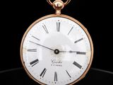 une montre de poche ancienne avec des chiffres romains sur un cadran noir