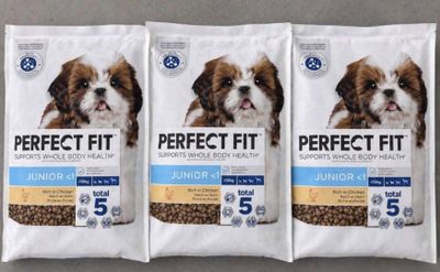 three bags of perfect fit dog food sitting on top of a table