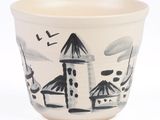 a white cup with a black and white drawing on it