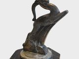 statue représentant un homme tenant la main d'une femme, posée sur un socle en marbre