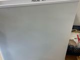 a white refrigerator sitting on top of a wooden table