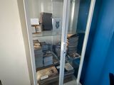 a glass display case filled with books in the corner of a room