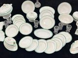 une photo d'un ensemble de plats et de tasses blancs et verts
