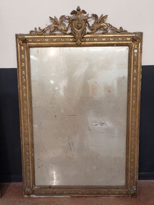 un miroir ancien à cadre doré posé sur un sol en marbre