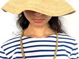 the woman is wearing a straw hat and a striped shirt