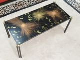 une table en verre ornée d'un motif noir et or