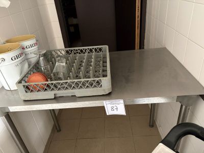 une table en métal sur laquelle est posé un panier de fruits