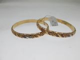 two gold tone bang bracelets on a white surface