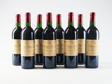 six bottles of wine are lined up in a row on a white surface
