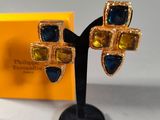 an image of a pair of blue and yellow earrings on a black stand
