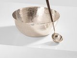 a close up of a metal bowl with a spoon in it