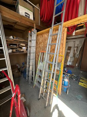 many ladders and tools in the garage of this house