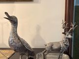 deux animaux en métal posés sur un plateau posé sur une table