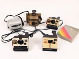 several polaroid cameras are lined up on a white surface