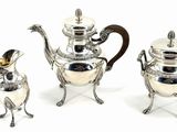 three pieces of silver tea and coffee set on a white background