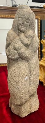 une statue représentant un homme tenant un bébé sur une couverture rouge