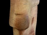 statue of a man ' s head made of clay on a black background