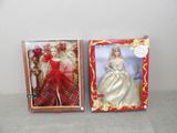 two boxed dolls of a woman in a red dress and a woman in a white dress