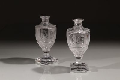 une paire de vases en verre transparent posés sur une table blanche