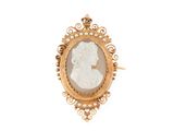 un gros plan sur une broche-camaïeu dorée et blanche