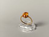 a close up of a gold ring with an orange stone on it