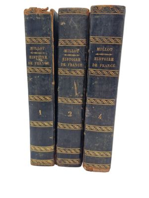 three old books sitting on top of each other on a white surface