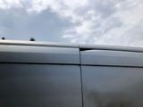 a black van with a white roof and a sky background