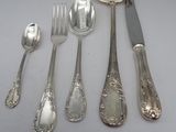 a lot of silver spoons and spoons on a table