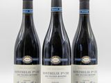 trois bouteilles de vin sont alignées sur une surface blanche