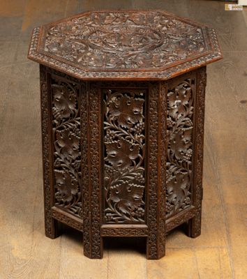 une table ancienne en bois ornée de sculptures, dans une pièce