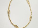 a gold chain bracelet with an oval link