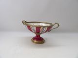 an image of a red and gold bowl on a white surface