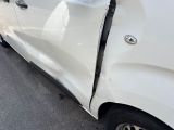 a white car that has been damaged and is parked on the side of the road