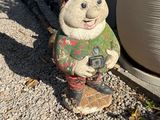 a statue of a snowman holding a camera on the ground
