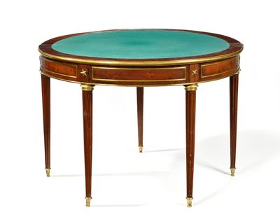 une table ovale avec un plateau en verre vert et des pieds dorés