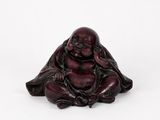 a small figurine of a laughing buddha on a white background