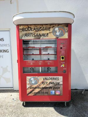 a red vending machine sitting on the side of a building
