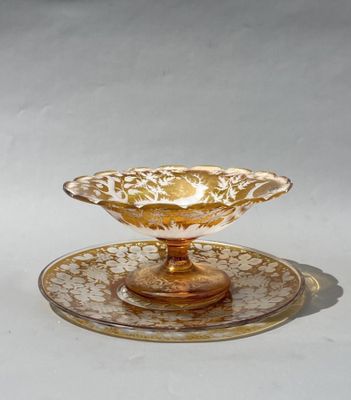 un bol et une soucoupe en verre jaune et blanc posés sur une surface blanche