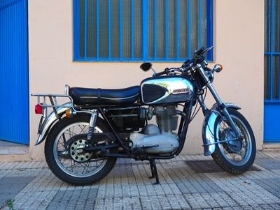 a motorcycle that is parked on the sidewalk in front of a building
