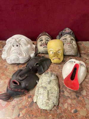 many masks on a table with a red background
