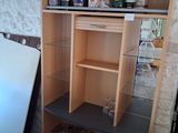 a refrigerator that is next to a shelf with bottles on it
