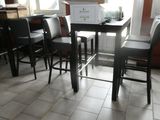 a small table and chairs in a room with a lot of windows