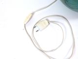 a green bowl with a white cord connected to it