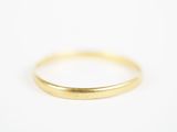 gros plan d'une bague en or sur une surface blanche