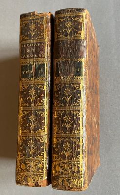 Deux vieux livres sont posés l'un sur l'autre sur une table