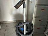 une image représentant un aspirateur posé sur un chariot bleu